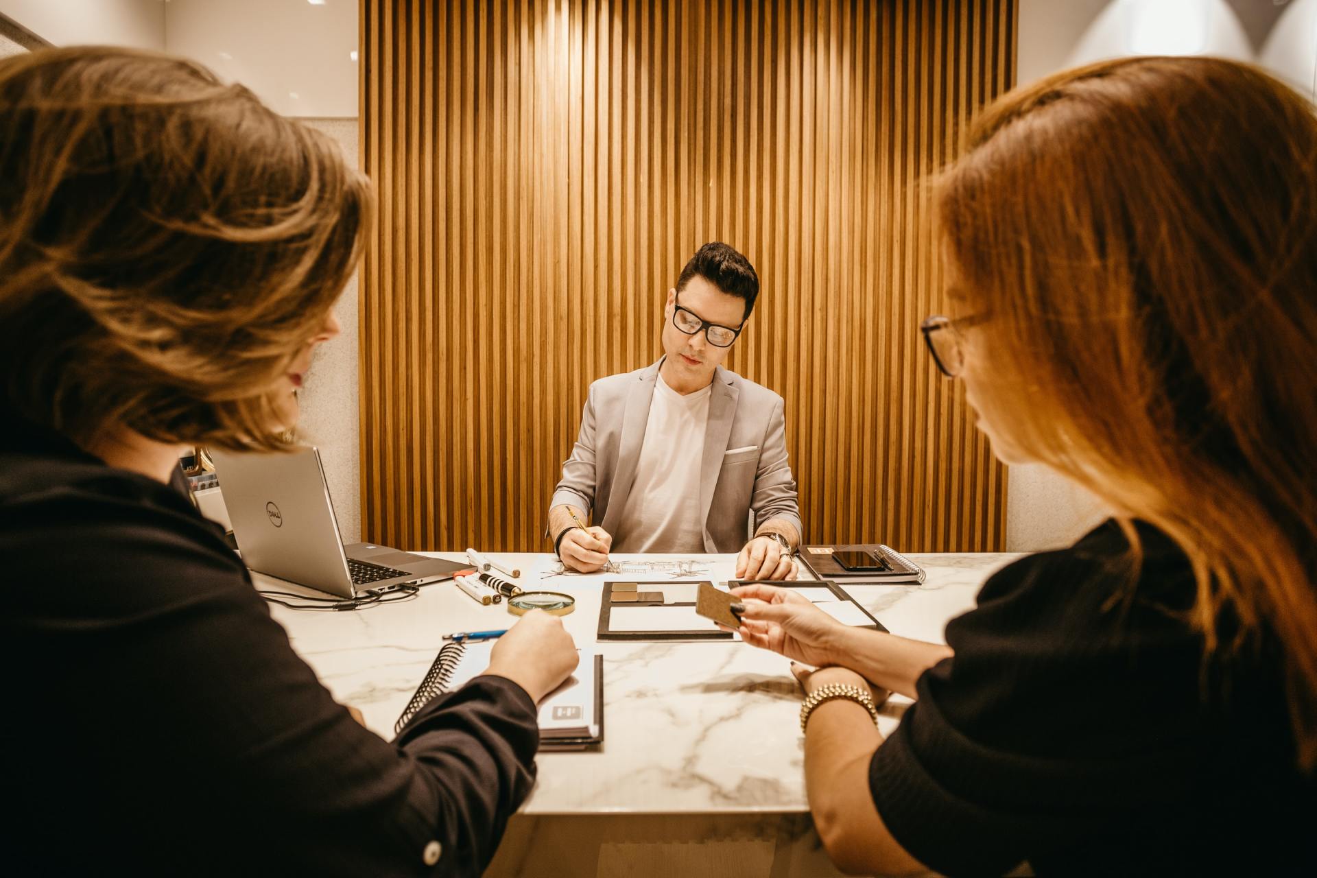 A Badger Business advisor reviewing documents with two clients